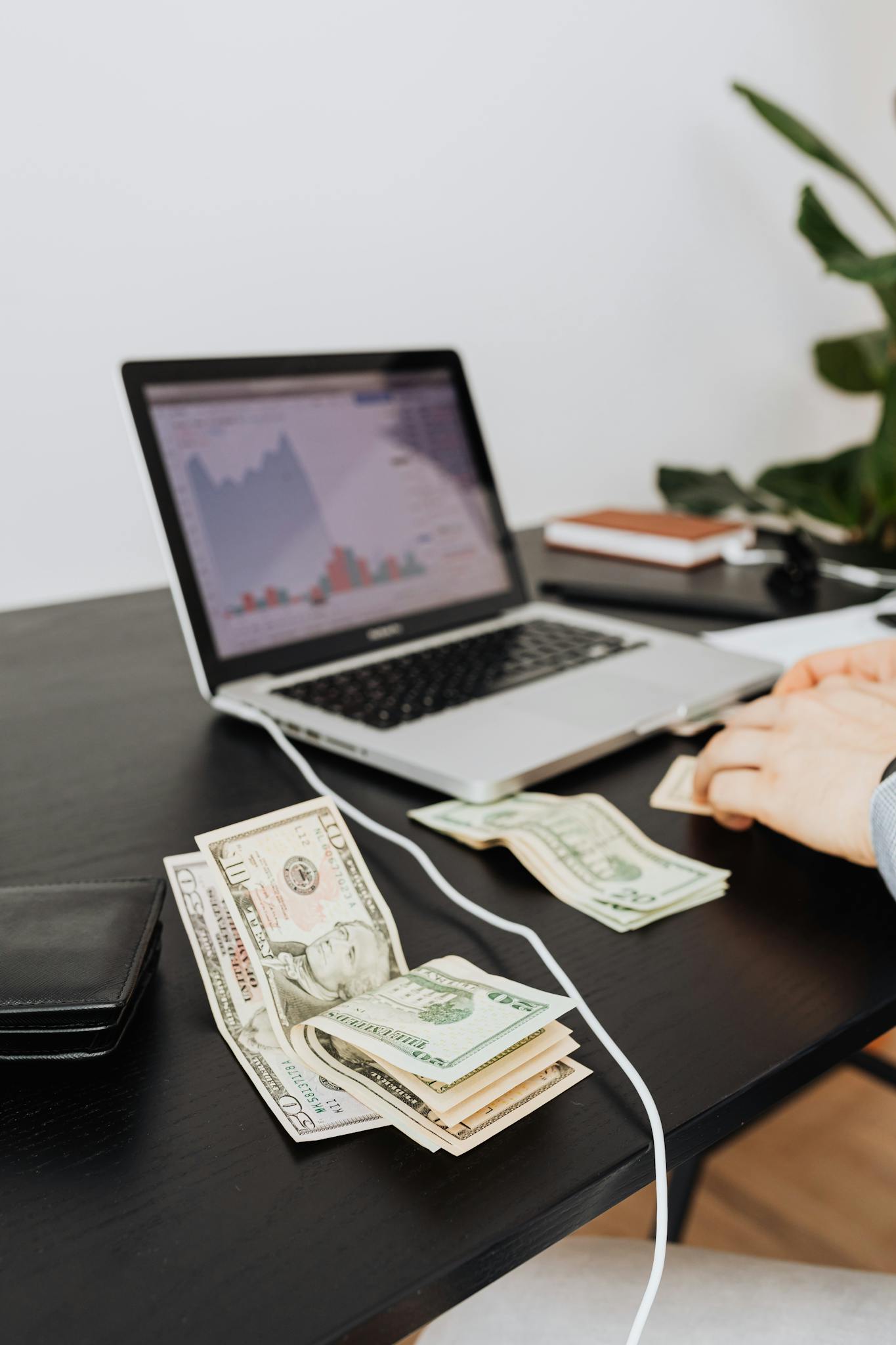 Money and laptop on desk indicating financial work or analysis. Perfect for business themes.